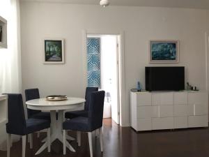 sala de estar con mesa, sillas y TV en Squere 44 Apartment, en Budva