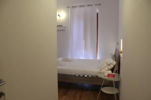 1 dormitorio con 1 cama con cortina blanca en I'MC IoAMoCagliari, en Cagliari