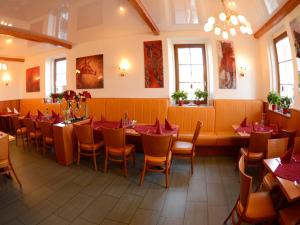 un ristorante con tavoli e sedie in una stanza di Hotel-Restaurant Rotes Einhorn Düren *** Superior a Düren - Eifel