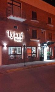 un panneau sur le côté de l'hôtel la nuit dans l'établissement Hotel Tykua, à Gualeguaychú