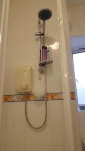 a shower in a bathroom with a shower head at Coiribe House B&SelfBreakfast in Galway