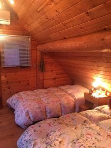 um quarto com 2 camas num chalé de madeira em Deja vu em Shika