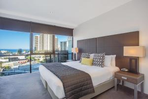 una camera da letto con un letto grande e una grande finestra di Mantra Circle On Cavill a Gold Coast