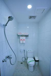 a bathroom with a toilet and a shower in it at King Park Hotel in Mandalay