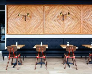 a restaurant with wooden tables and red chairs at Boro Hotel in Queens