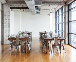 a large room with wooden tables and chairs at Boro Hotel in Queens