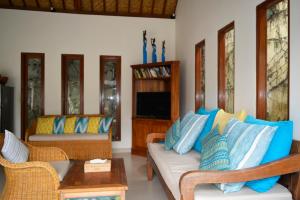 a living room with a couch and a tv at Villa Mewali in Ubud