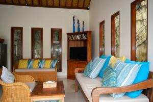 sala de estar con sofá y TV en Villa Mewali, en Ubud