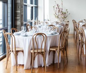 a dining room with tables and chairs with glasses on them at Boro Hotel in Queens