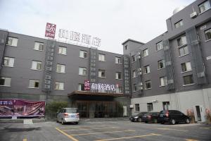 Un gran edificio con coches aparcados en un estacionamiento. en Atour X Hotel Shanghai Hongqiao Airport Konggang Road, en Shanghái