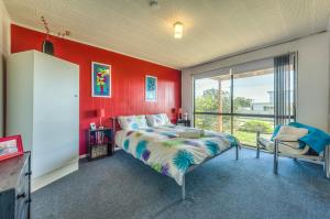 a bedroom with a bed and a red wall at Bayviews in Portarlington