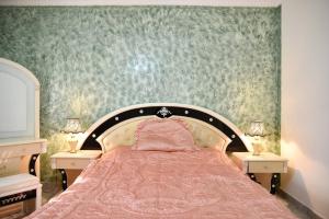 a bedroom with a pink bed with two night stands at Fancy apartment in front of City Stars in Cairo