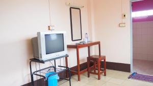 a television sitting on a stand in a room at Charinsup Hotel in Ban Khlong Thai Muang