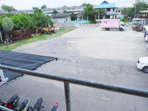 a view of a parking lot with a pink truck at Charinsup Hotel in Ban Khlong Thai Muang