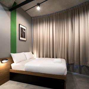 ein Schlafzimmer mit einem Bett und einer grünen Wand in der Unterkunft Tido Hostel Penang in George Town