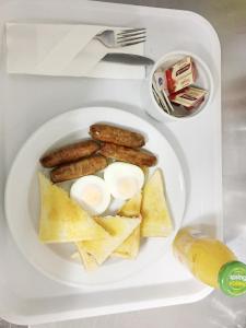 a plate of breakfast food with eggs sausage and crackers at Motel St Arnaud in Saint Arnaud