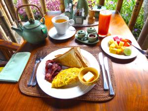 stół z talerzem śniadaniowym z jajkami i tostami w obiekcie Puri Dajuma Villas w mieście Pulukan