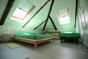 a bedroom with two green beds and two windows at Villa Maria in Turin