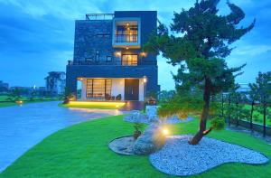 una casa con un árbol delante de ella en Qi Li Xiang Homestay, en Wujie