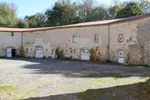 duży ceglany budynek z białymi drzwiami i dziedzińcem w obiekcie La Loge du Château w mieście Saint-Dier-dʼAuvergne