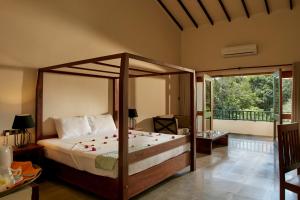 a bedroom with a canopy bed and a balcony at Sevanagama in Habarana