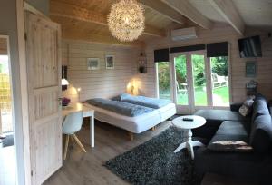 een woonkamer met een bank en een kroonluchter bij Piccobello Bed & Breakfast Valløby Køge in Valløby