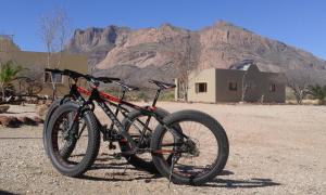 a bike parked in the desert with a mountain in the background at Hohenstein Lodge in Usakos