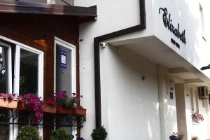 un edificio blanco con cajas de flores en el balcón en Elizabeth House, en Skopje