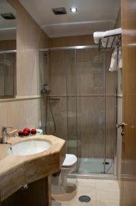 a bathroom with a shower and a sink and a toilet at Hostal Restaurante La Cepa in Cariño