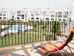 einen Balkon mit einem Stuhl und einem Pool in der Unterkunft Coming Home - Penthouses La Torre Golf Resort in Roldán