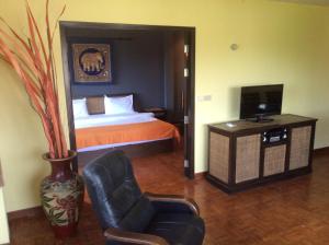 a bedroom with a bed and a chair and a couch at Cocco Resort in Pattaya South