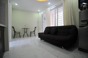 a living room with a black couch and a table at Greenfield Nha Trang Apartments for rent in Nha Trang