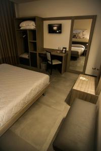 una camera con letto, scrivania e specchio di La Sosta Motel Tavola Calda a Matera