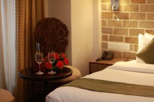 a hotel room with two glasses and flowers on a table at Hotel Arts Kathmandu in Kathmandu