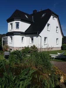 a large white house with a black roof at Haus Elsholz Usseln FeWo Birke in Willingen