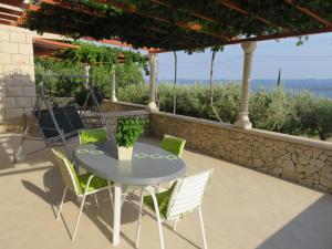 a table and chairs on a patio with a view at Apartments Podbarje in Bol