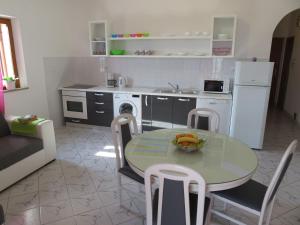 a kitchen with a table with a bowl of fruit on it at Apartments Podbarje in Bol