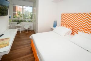 索倫托的住宿－Casa Pantone，白色卧室配有一张大床和一张书桌