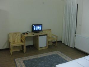 Zimmer mit Schreibtisch und TV in der Unterkunft Hotel Marub in Rubik