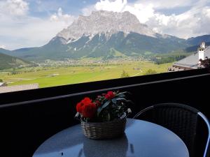 a basket of flowers sitting on a table with a mountain at Sporthotel Pechtl in Lermoos