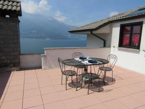 eine Terrasse mit einem Tisch und Stühlen auf dem Balkon in der Unterkunft LUCY'S HOUSE in Bellano