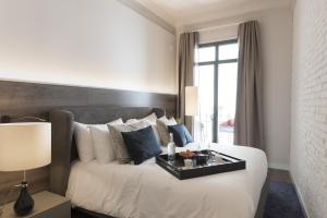 A bed or beds in a room at Casagrand Luxury Suites Barcelona