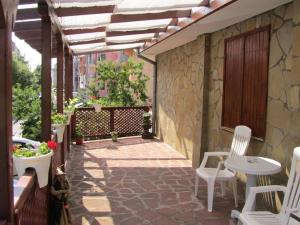 a patio with white chairs and a table at House Sofia in Sveti Vlas