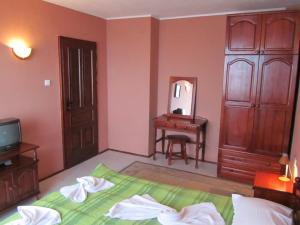 a bedroom with a bed and a dresser and a mirror at House Sofia in Sveti Vlas