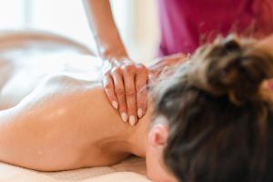 a woman getting a back massage from a therapist at Park-Hotel Hübner in Warnemünde