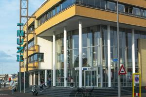 ein großes Gebäude mit Leuten, die davor laufen in der Unterkunft Strandzand in Noordwijk aan Zee