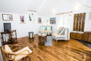 sala de estar con suelo de madera y paredes blancas en Apartments Kuća Mala, en Split