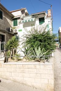 un edificio bianco con piante davanti di Apartments Kuća Mala a Spalato (Split)