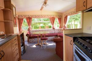 a kitchen with a couch and a table in a caravan at Holiday Lodge in Pogorzelica