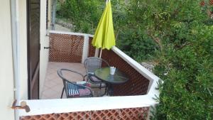 a patio with a table and a yellow umbrella at Apartments Andrea in Baška
